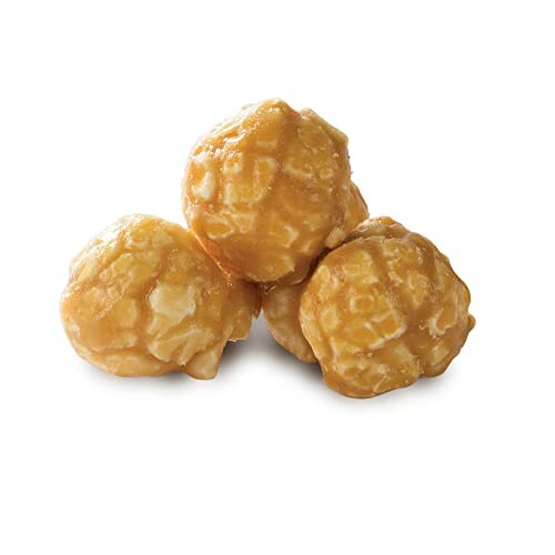 Three caramel-coated popcorn balls on a white background.