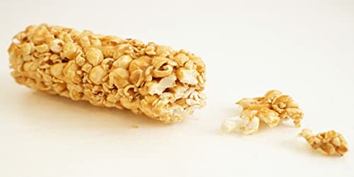 Caramel-coated popcorn bar with a small broken piece on white background