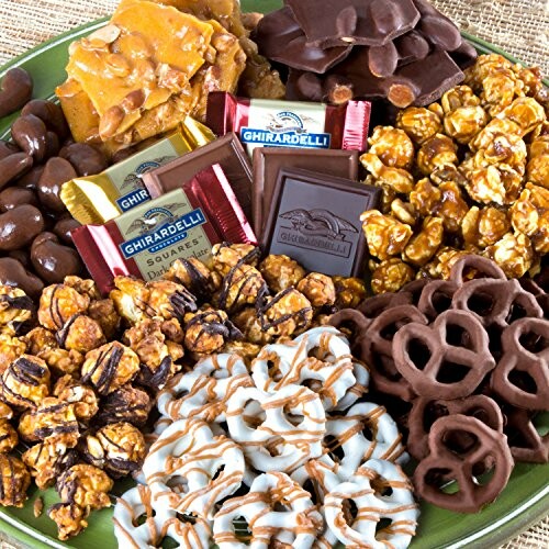 Assortment of chocolates, caramel popcorn, and pretzels on a plate.