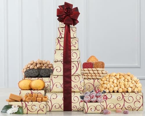 A decorative gift tower with various snacks and a red ribbon.